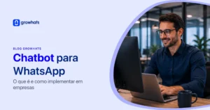 Imagem de capa do blog Growhats sobre Chatbot para WhatsApp. Texto: "Chatbot para WhatsApp: O que é e como implementar em empresas". À direita, um homem sorridente de óculos trabalha em um escritório utilizando computador e notebook.