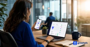 Profissional em escritório usando celular e notebook com gráficos e dashboards de dados, trabalhando em análise e relatórios digitais durante o expediente
